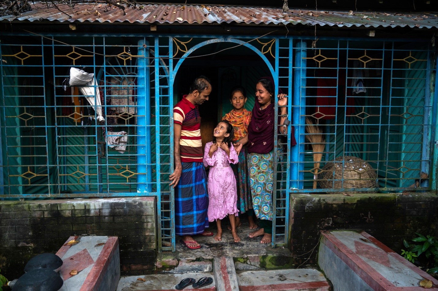 Father, mother and two girls standing in a doorway 