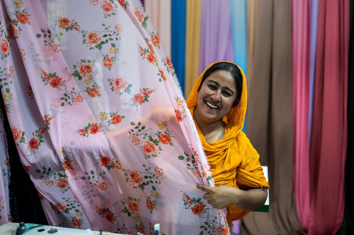 A lady holding fabric, smiling