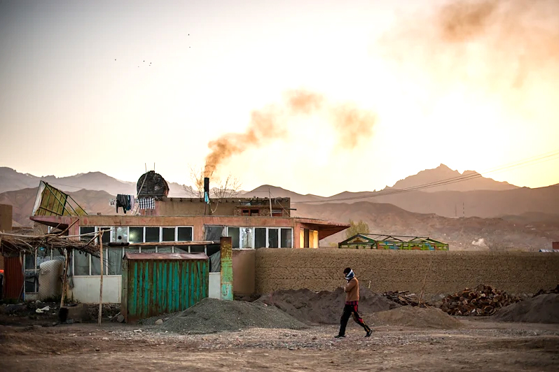 A man walks down a rural street in Afghanistan