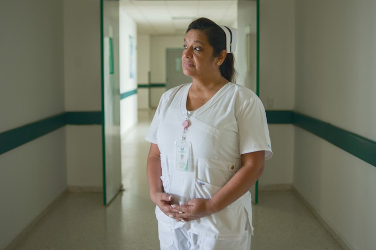 A nurse standing at a hospital corridor