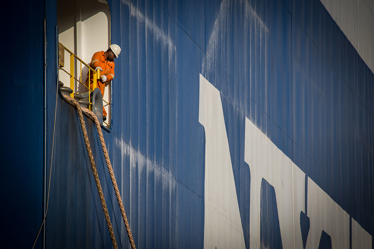 a man working on the side of a shipping container