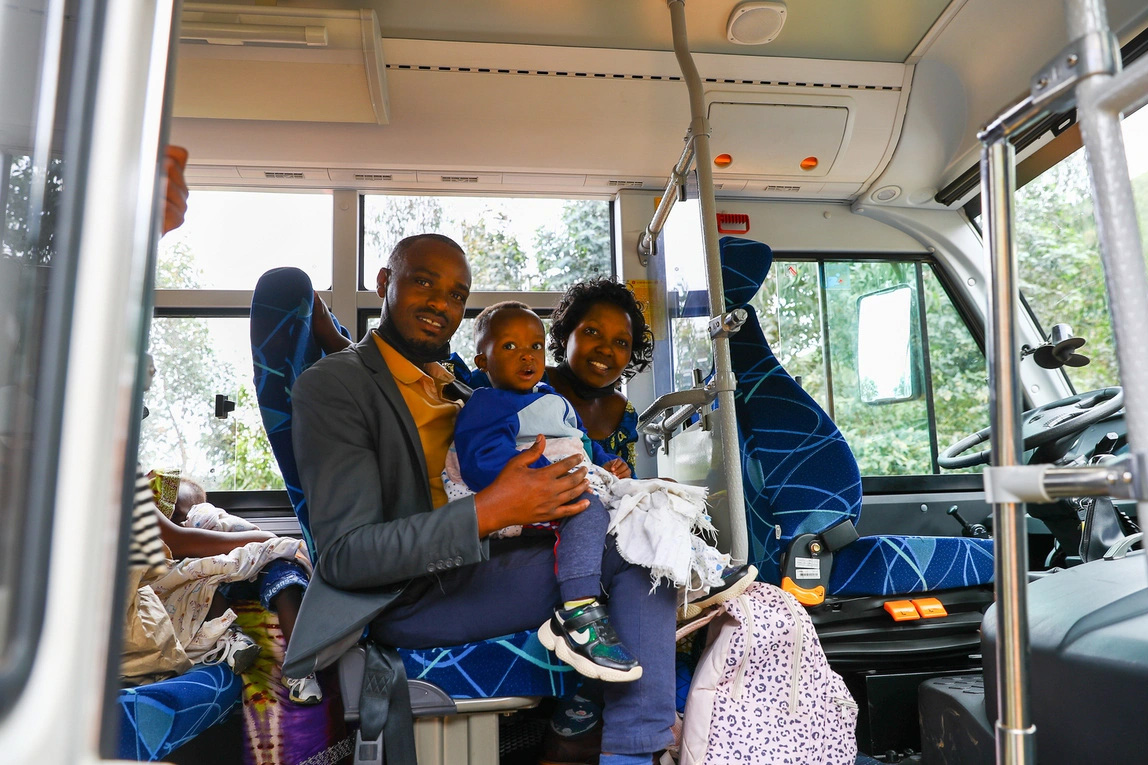 mom, dad and a toddler sit inside a bus