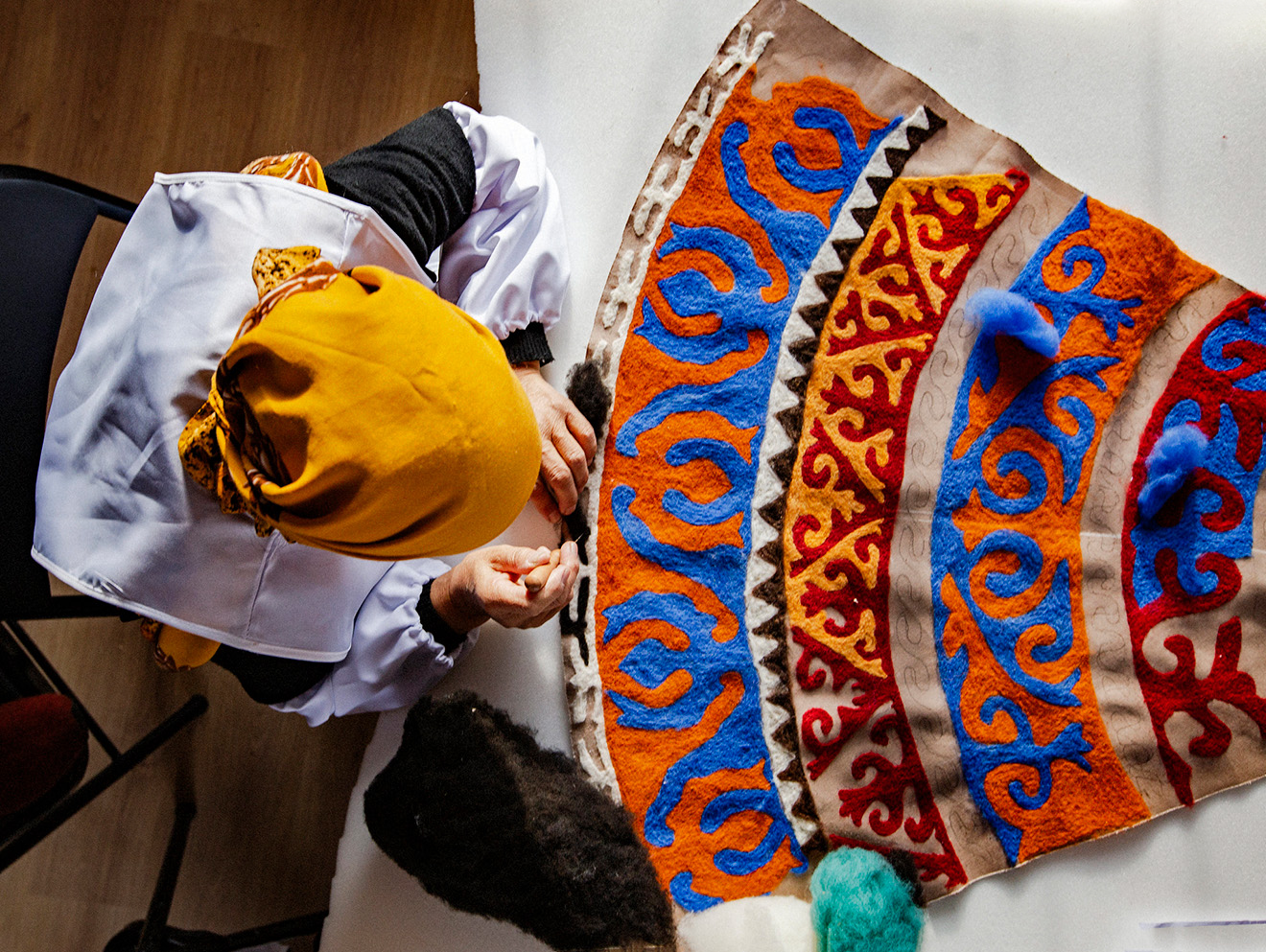 A woman working with felt details on the skirt.