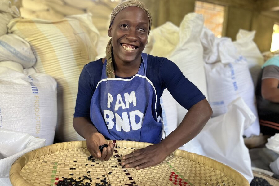 Smiling woman while sifting beans