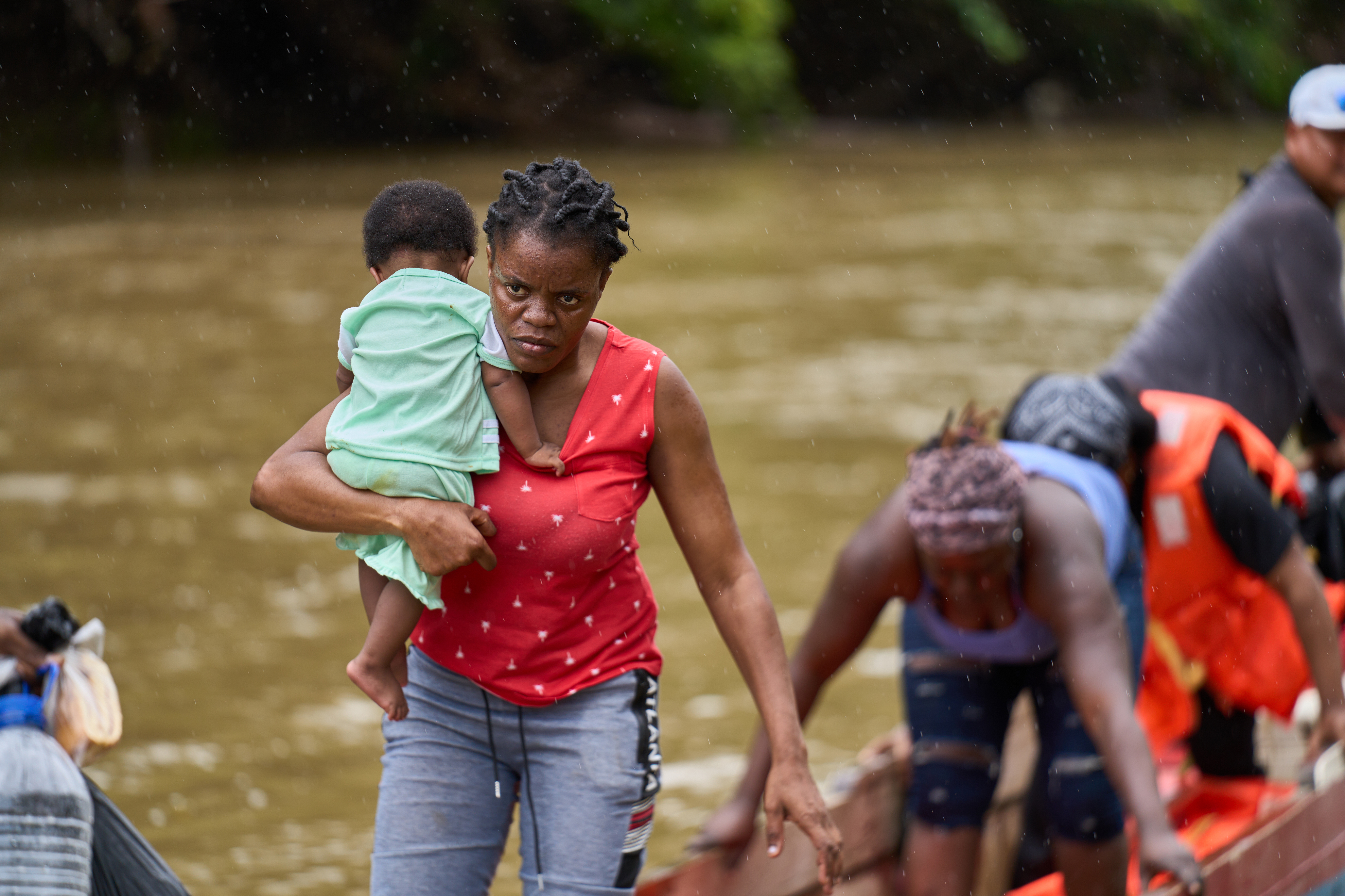 A mother holding her baby coming off a boat