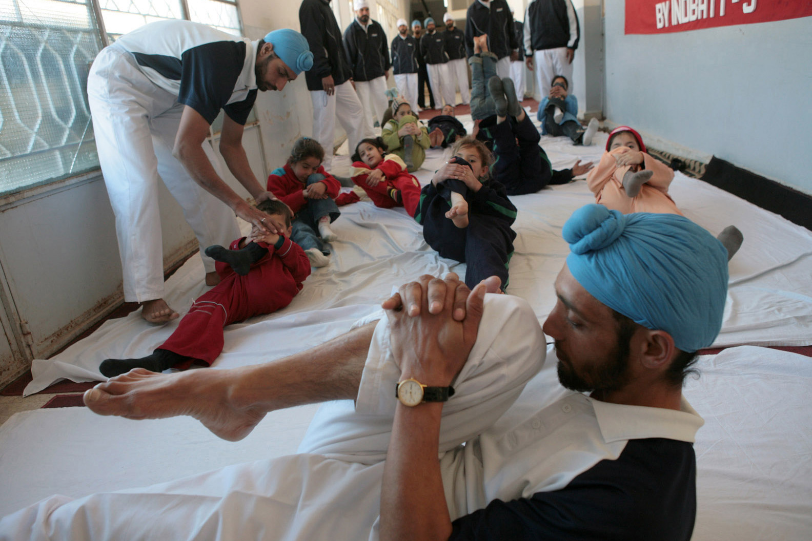 adults and children practicing yoga moves