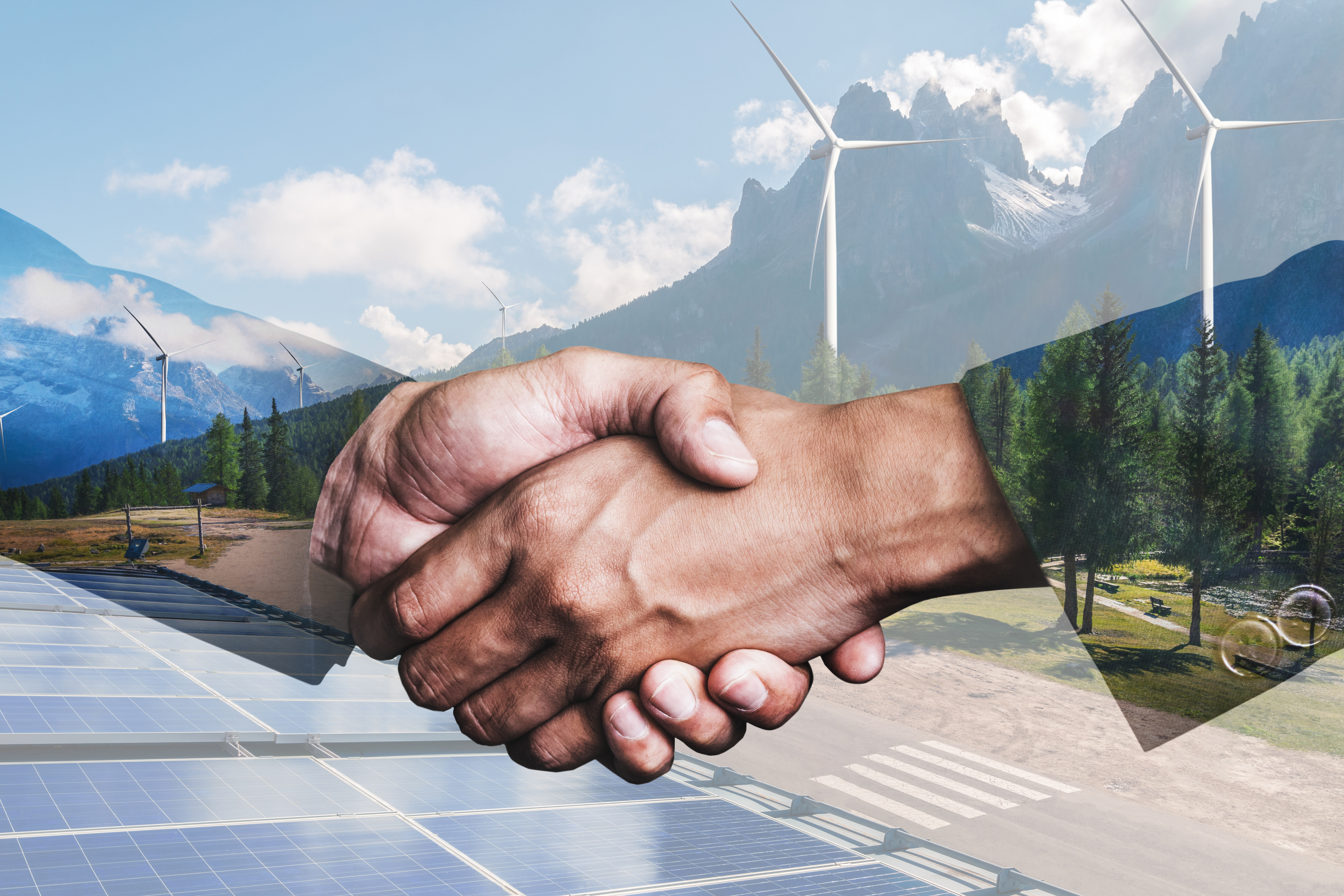A background of a wind turbine farm in view of a handshake.