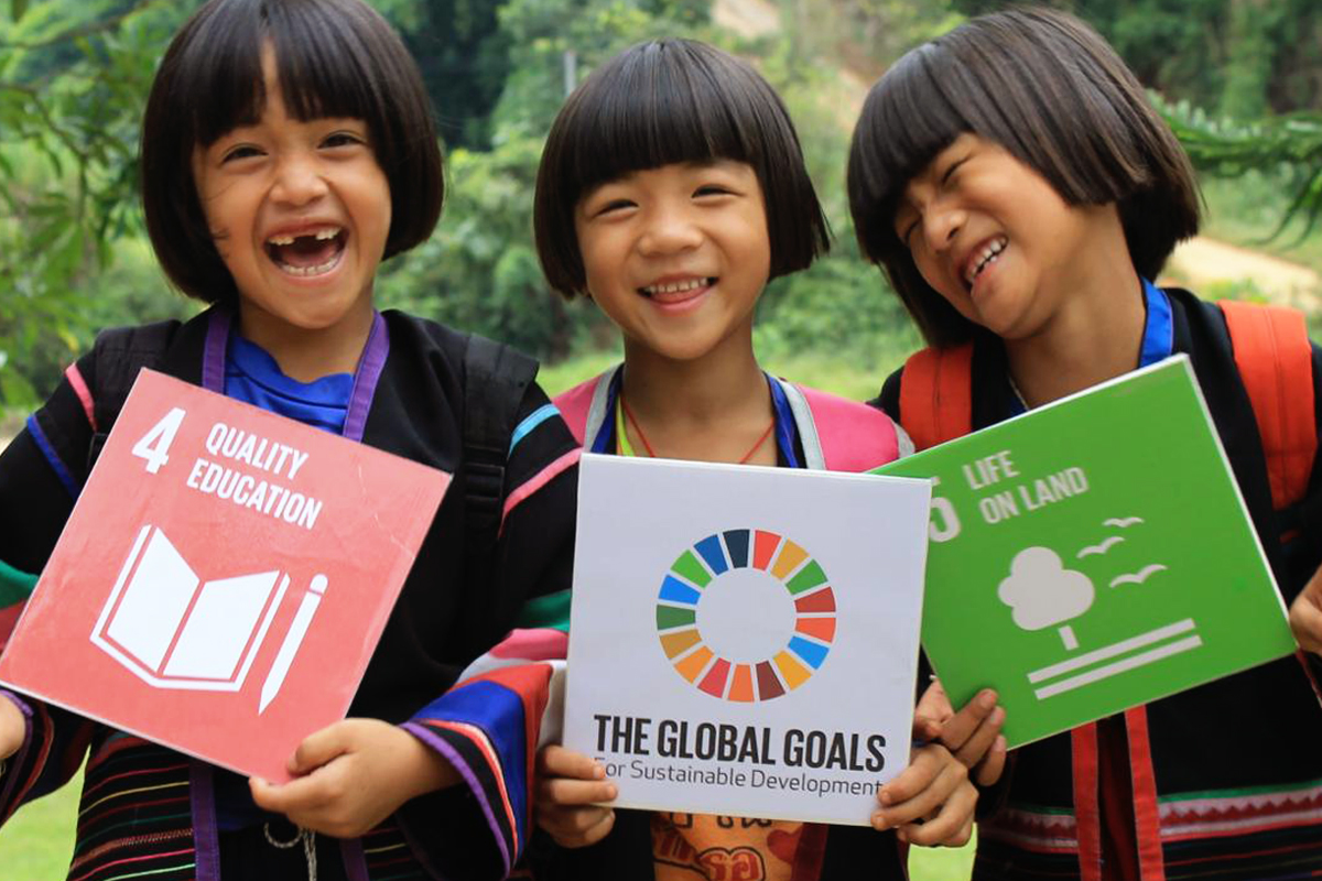 3 happy girls hold up SDG cards for a photo shoot