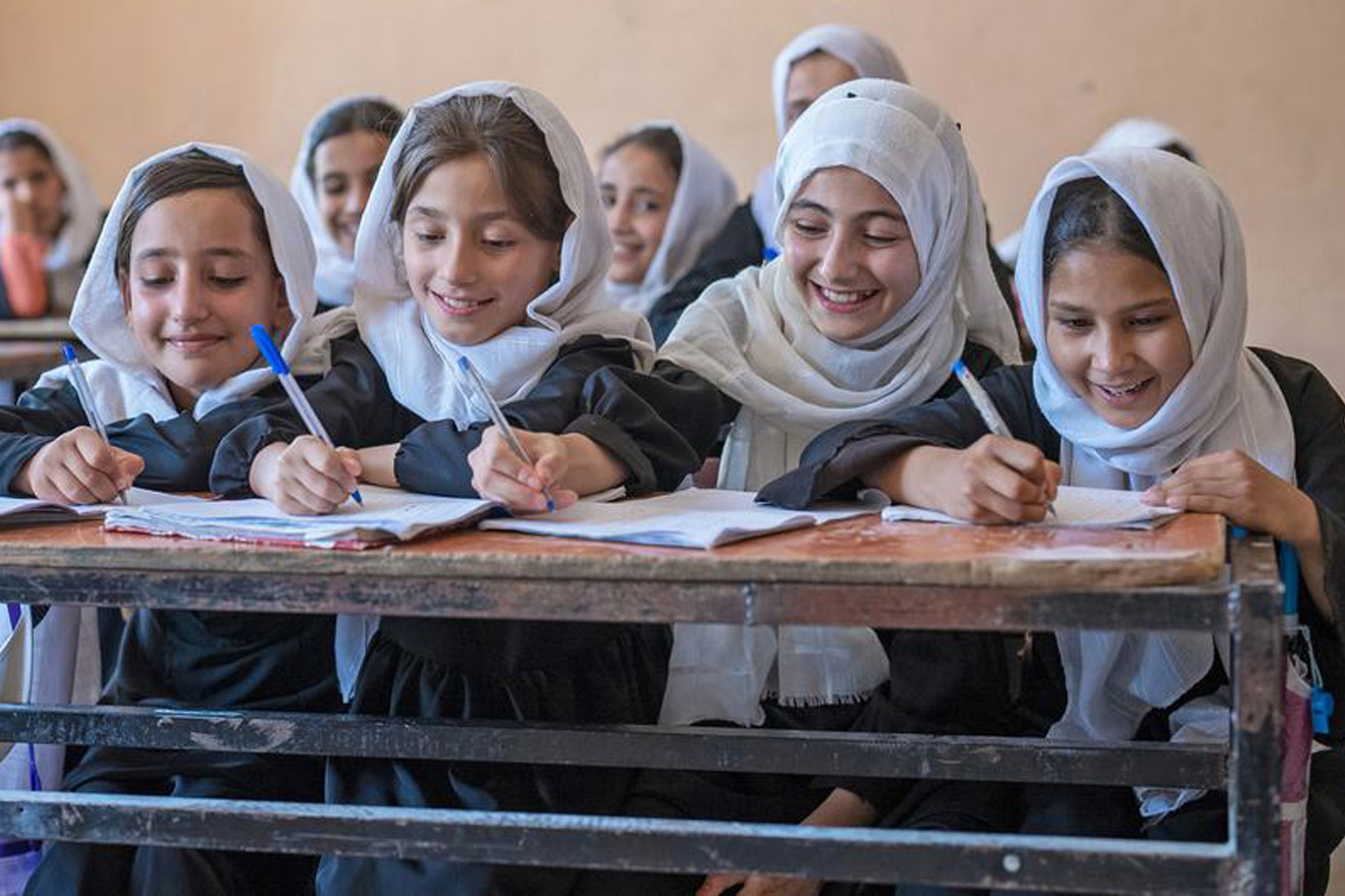 Four Afghan girls studying in a classroom.