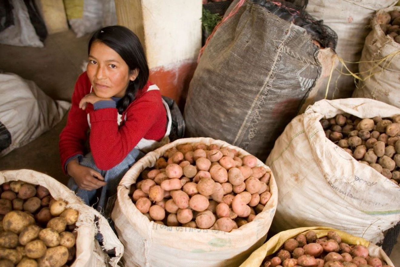 A woman encircled by potato bags.