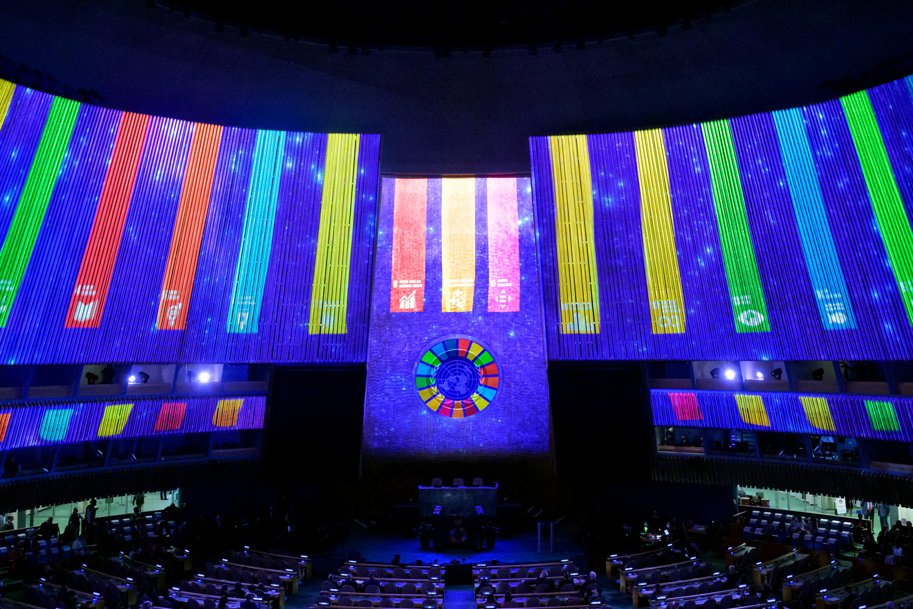 General Assembly hall with the SDG logos and colors projected on its walls. 