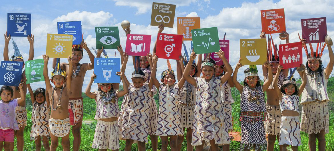 kids holding up cards with SDGs