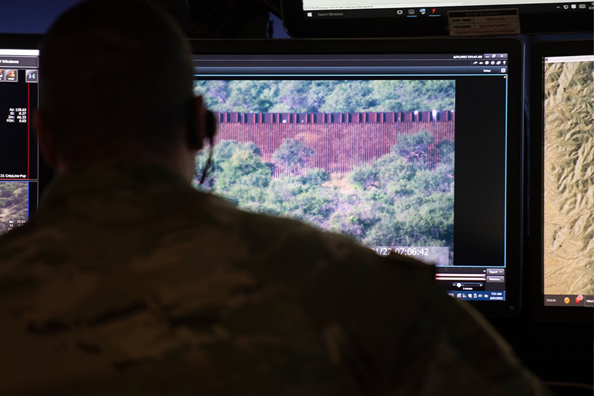 A man looking at several border surveillance monitors.