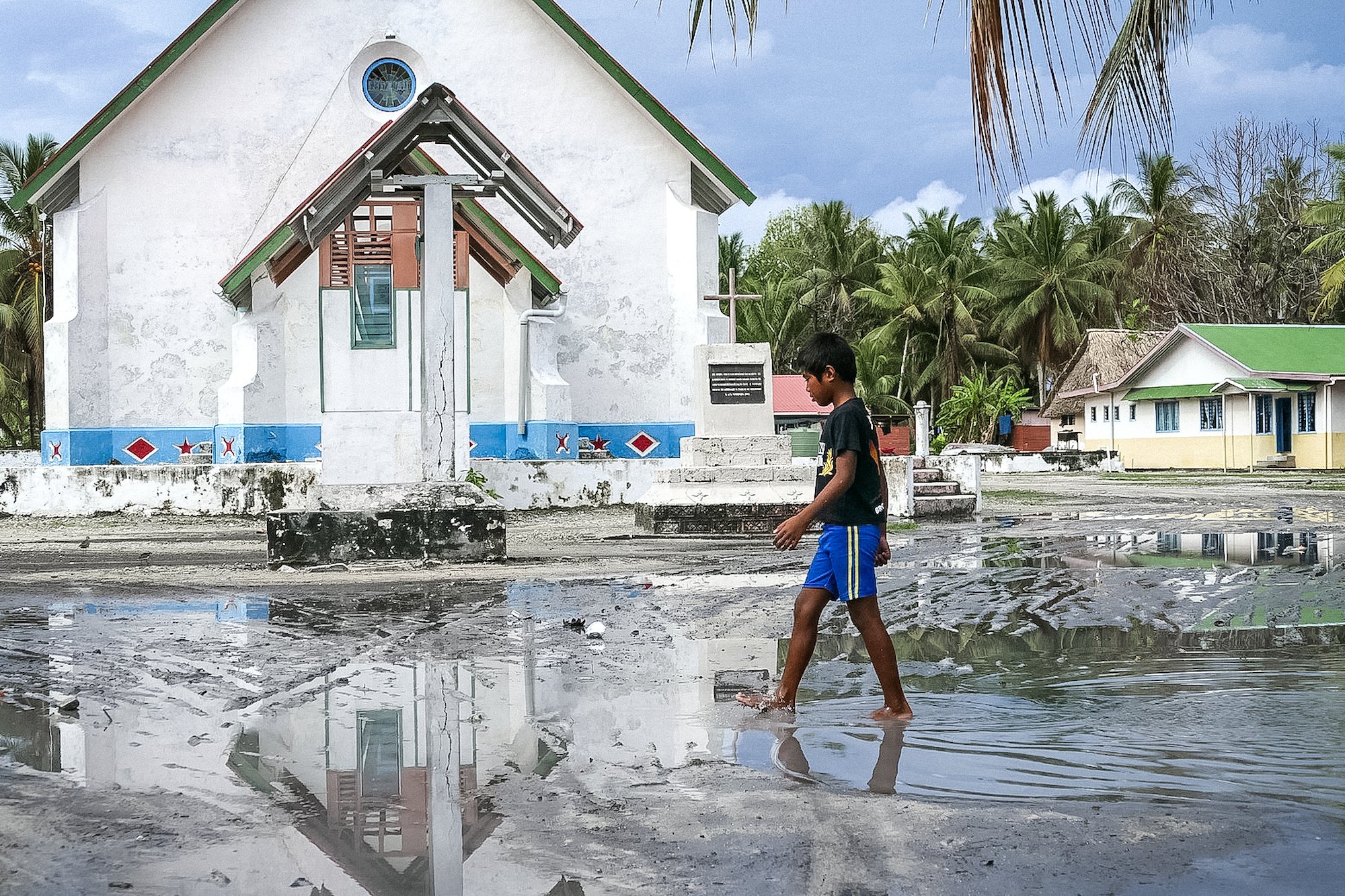 A boy walking in stagnant water after a Cyclone Pam in Vanuatu. 