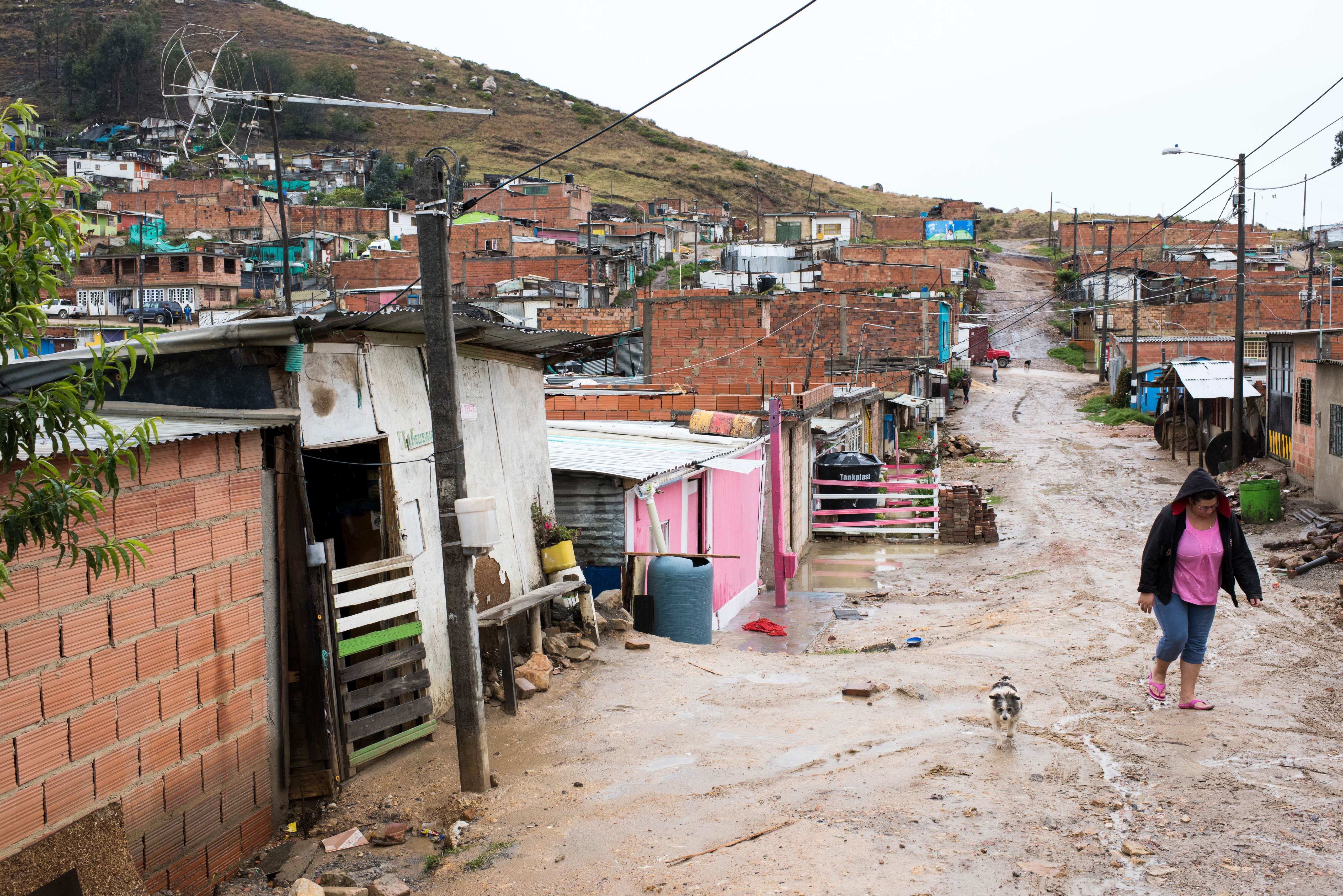 A woman walking through a slum area in Columbia.