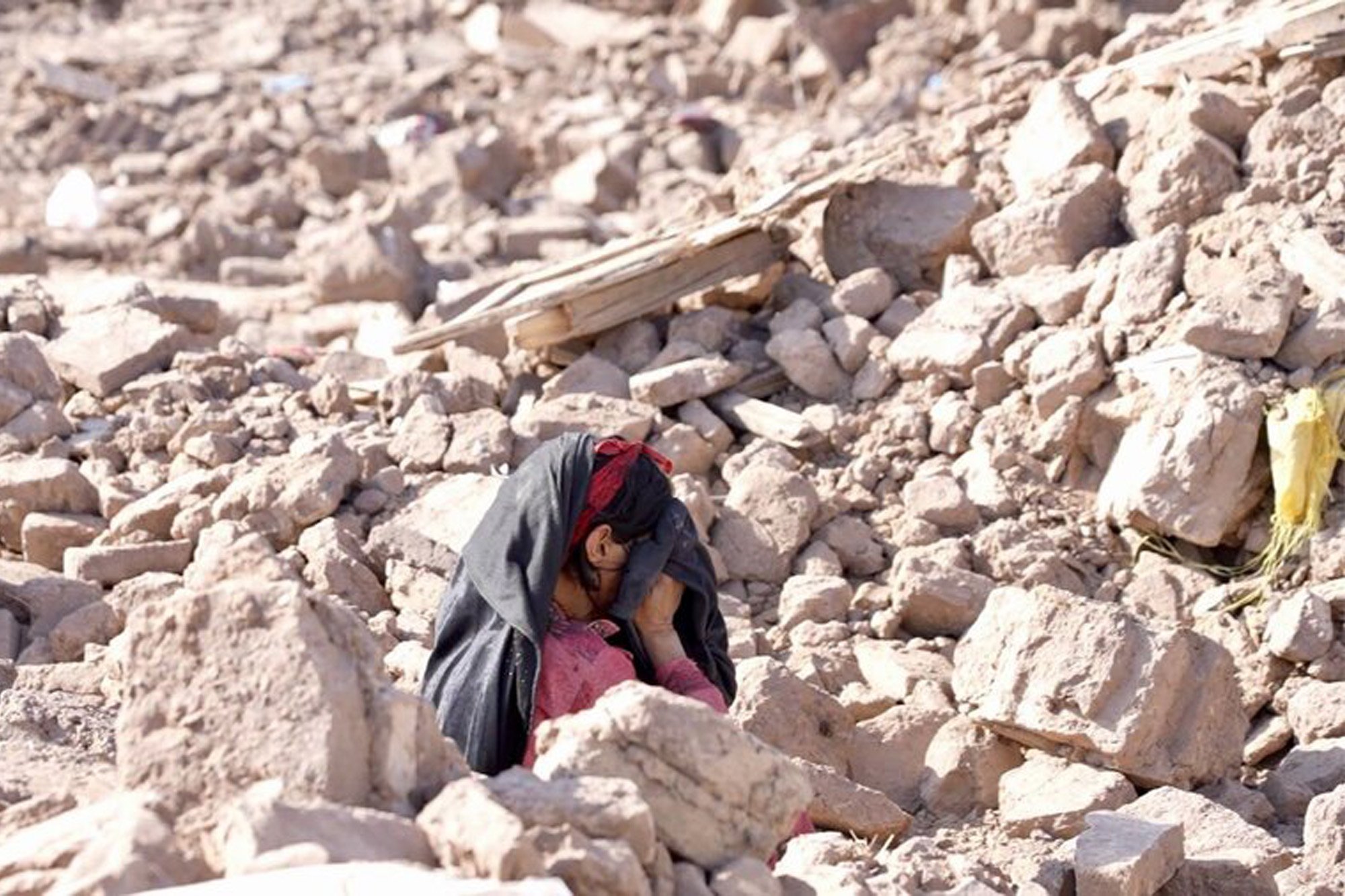A grief-stricken woman in the rubble from the recent earthquake in Afghanistan.