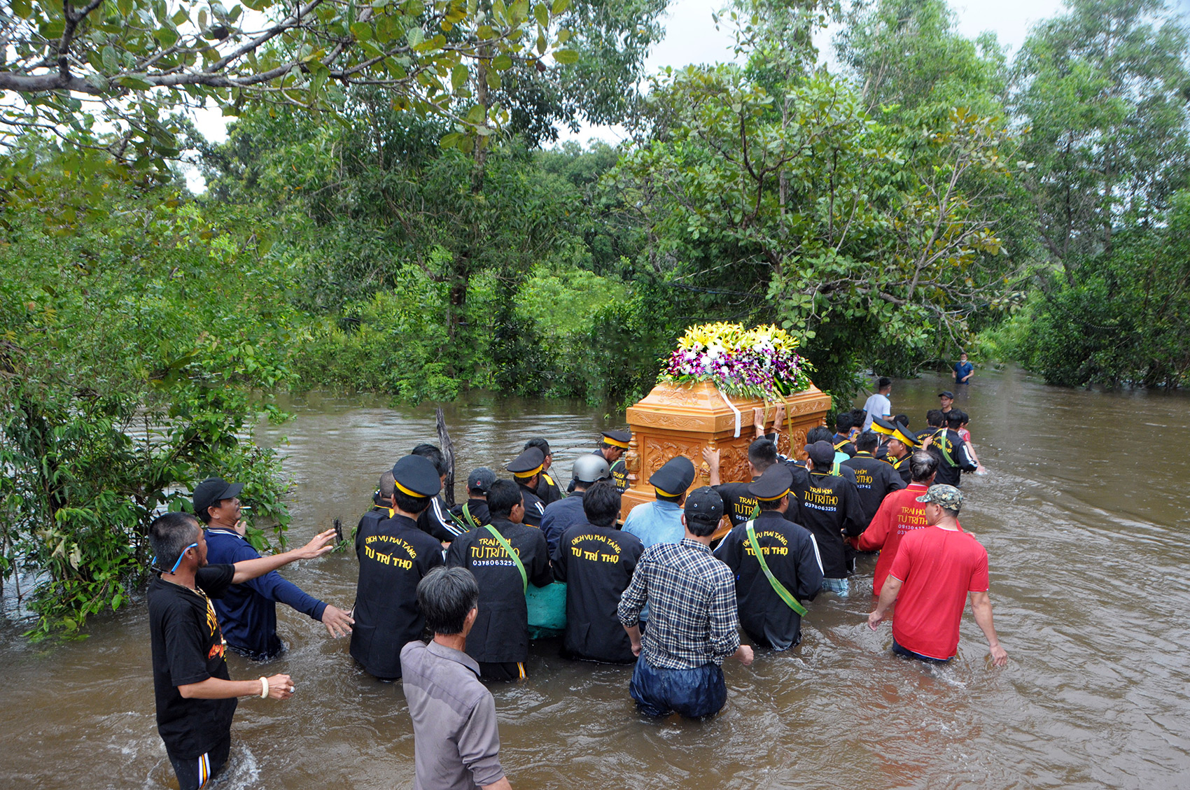 Men pushing a casket on a river