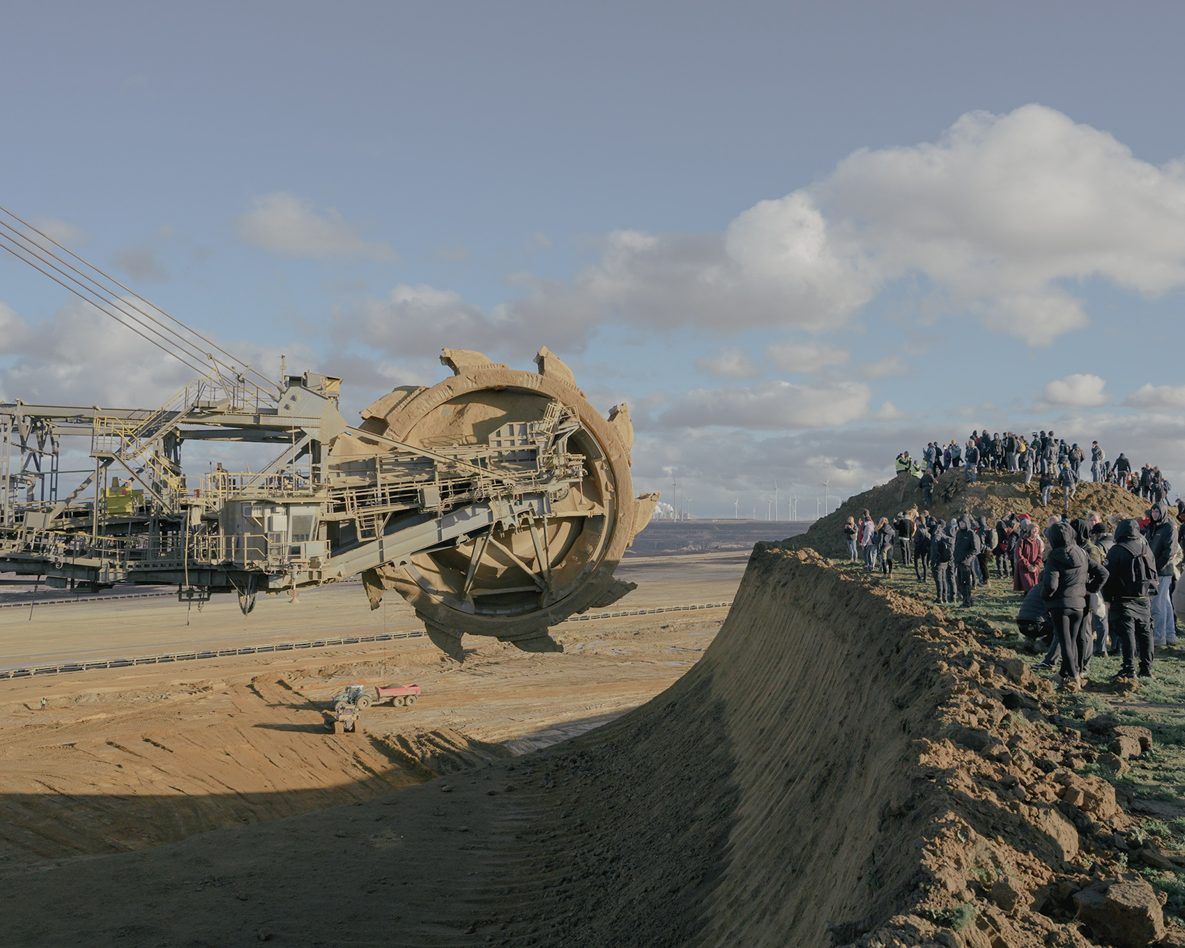 Group of activists blocking an excavator on the edge of an open-pit coal mine
