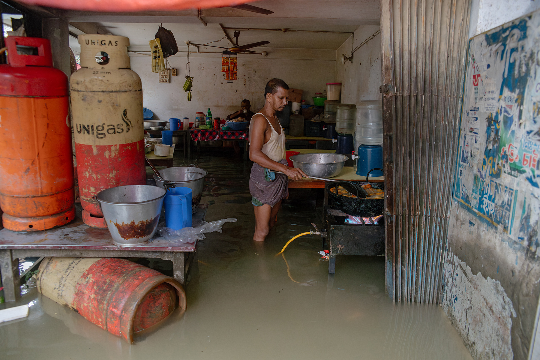 A man cooking in his flooded kitchen