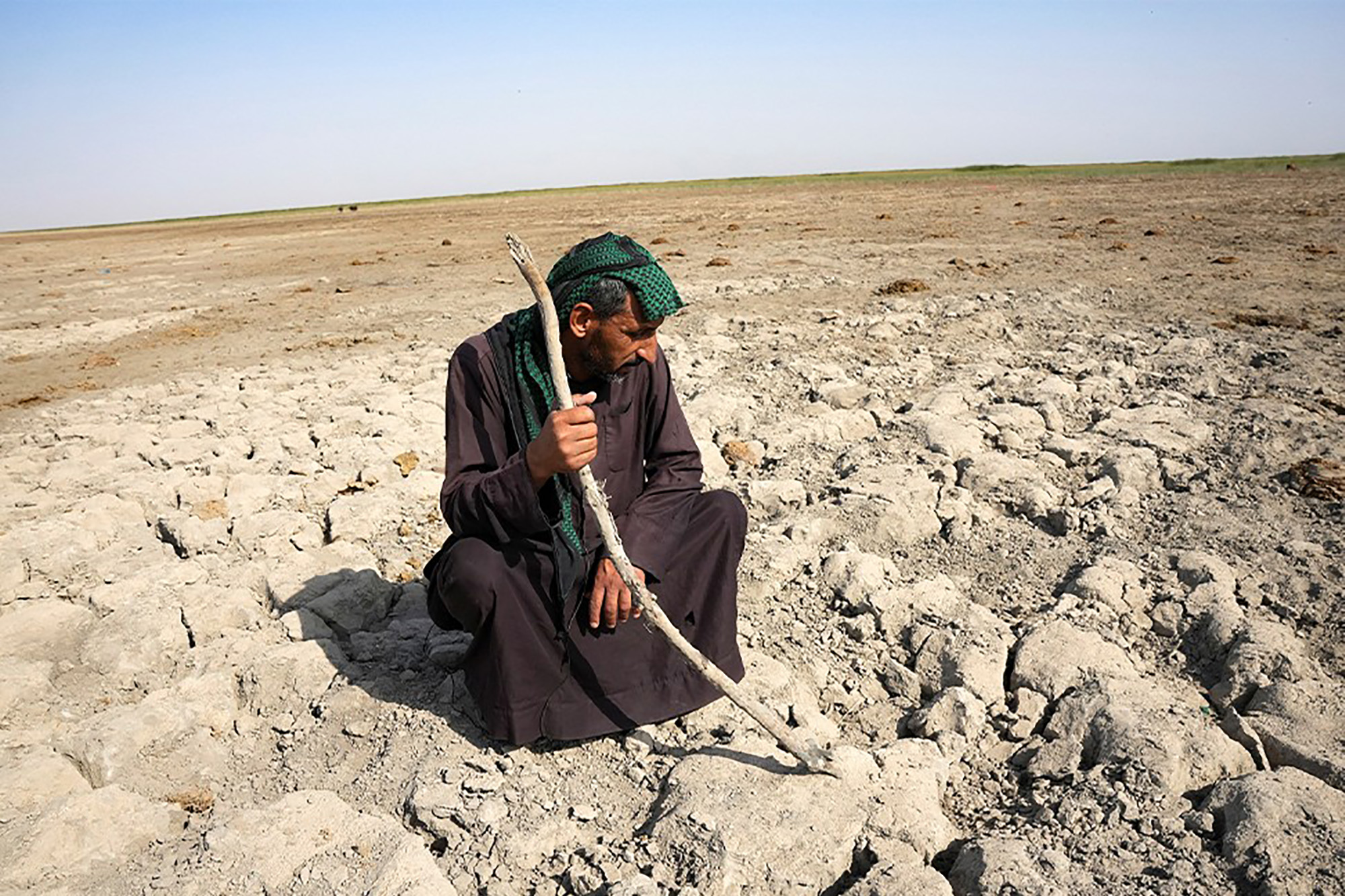 A Marsh Arab man, the wetlands' indigenous population of Iraq, looking at a dry ground.