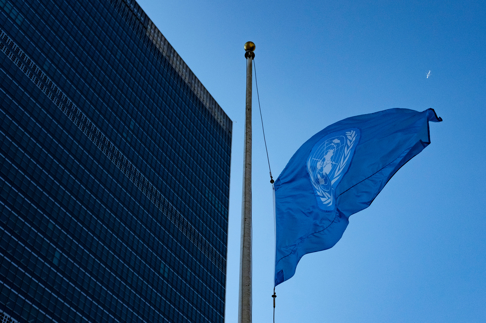 the UN flag in front of the Secretariat building at half-mast