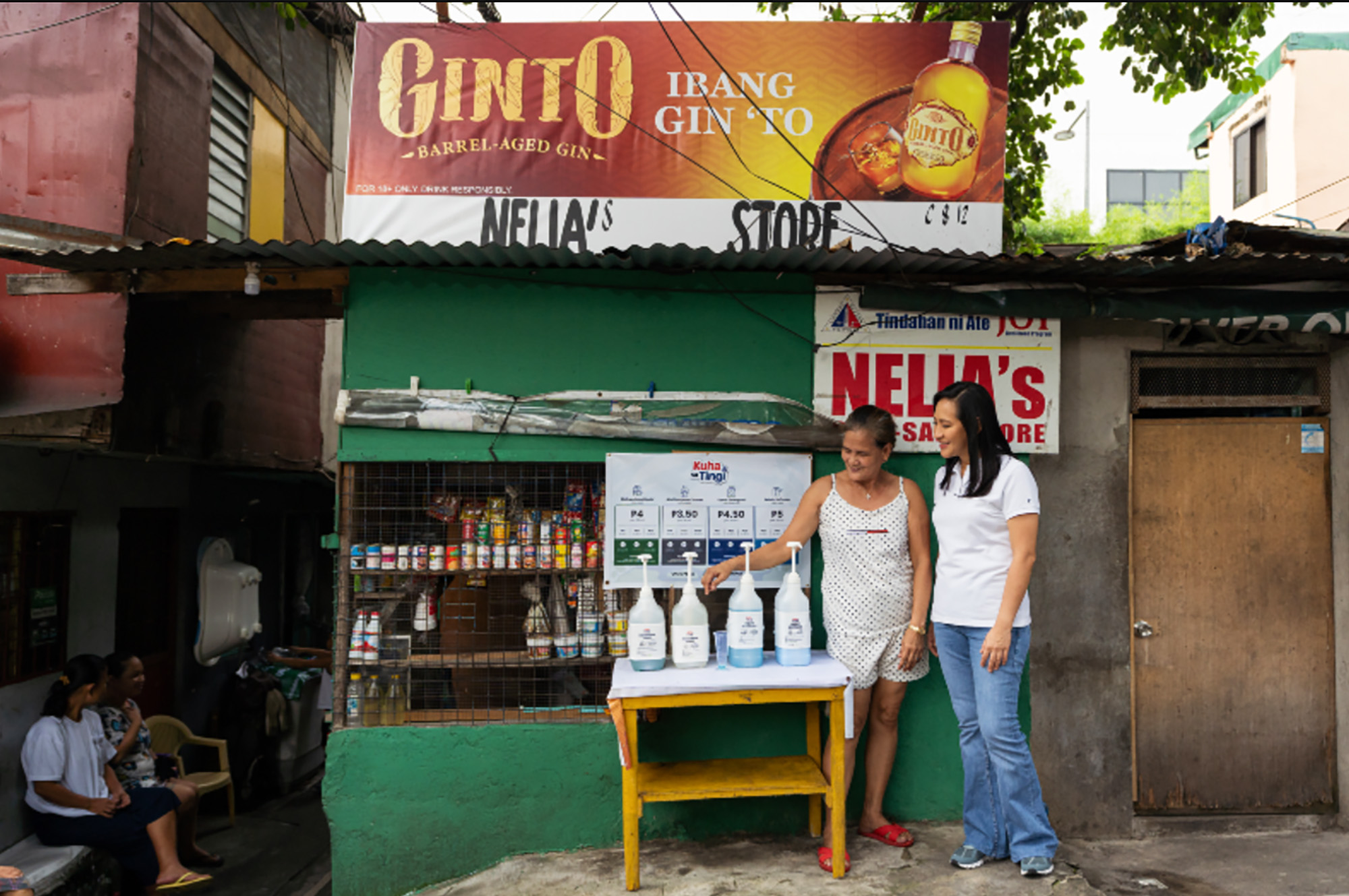 Two women stand in front of a convenience store that aims to reduce plastic pollution.