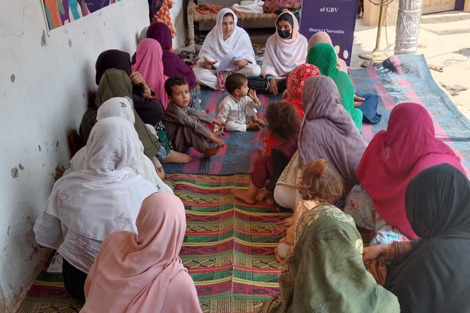 A group of women and young girls discussing menstrual health. 