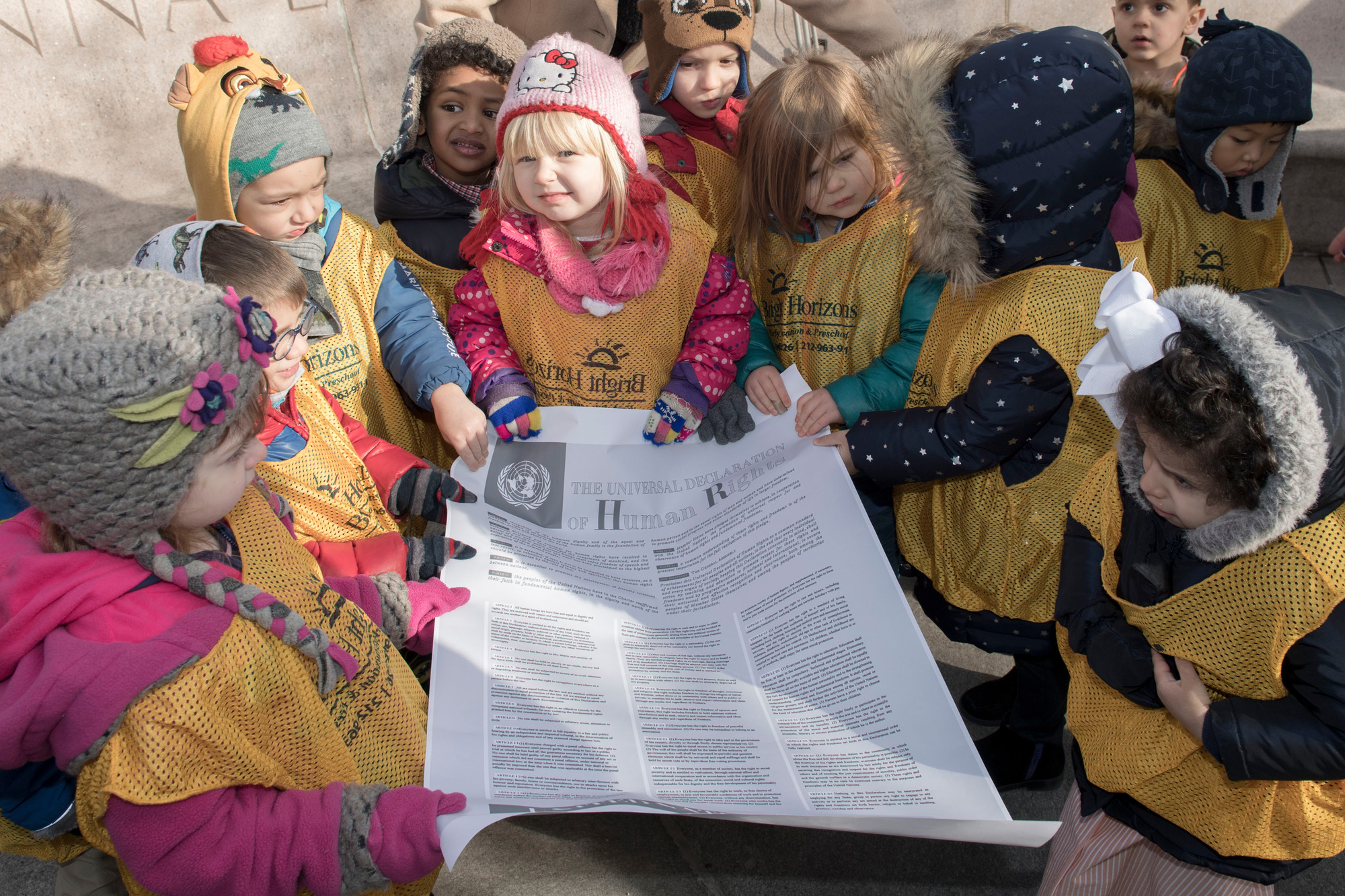 A group of children holding a copy of the Universal Declaration of Human Rights.