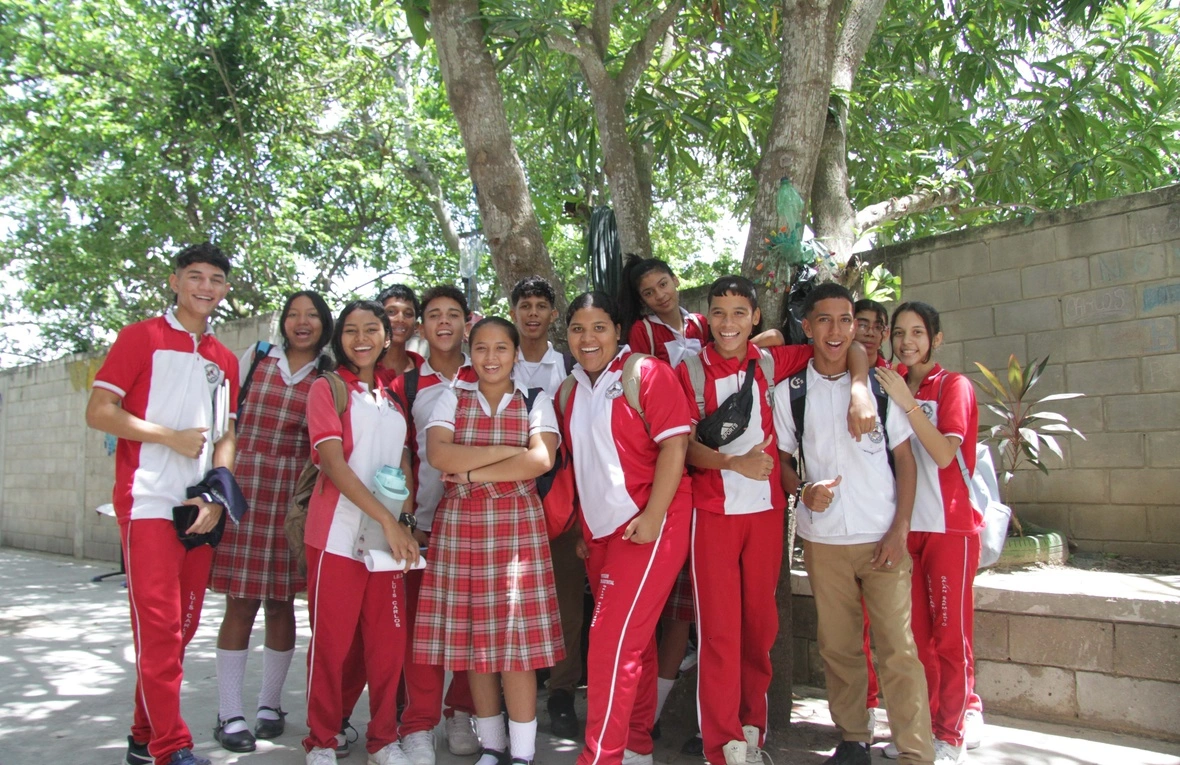 Un grupo de estudiantes en uniforme posan ante la cámara.