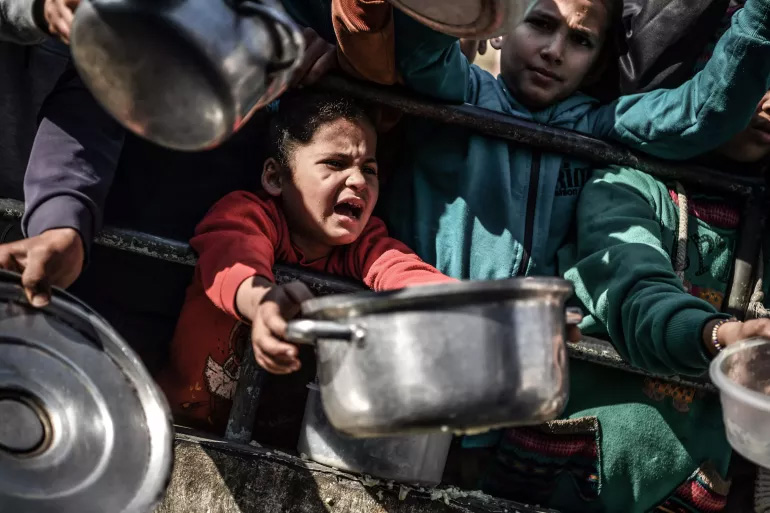 children holding out metal pots