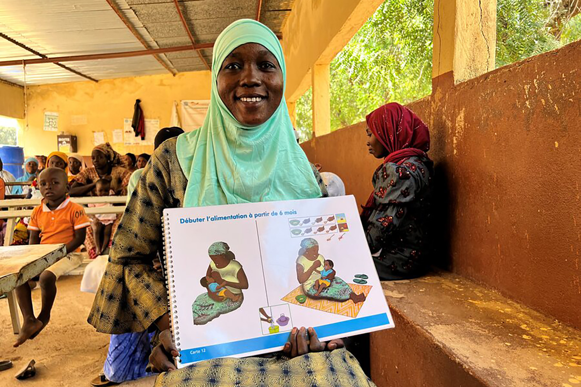 A Woman shows a book on healthy dietary practices for babies.