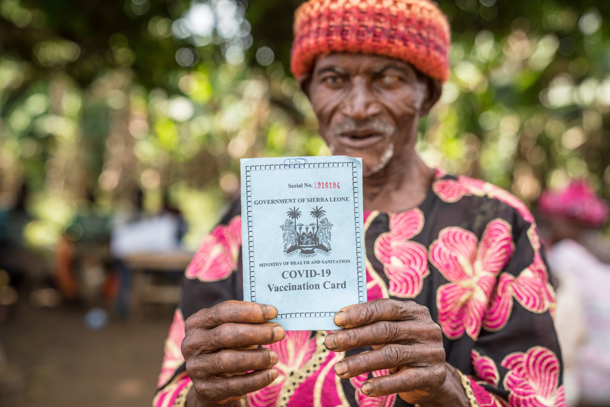 A man shows his Covid-19 vaccination card in Serra Leone.