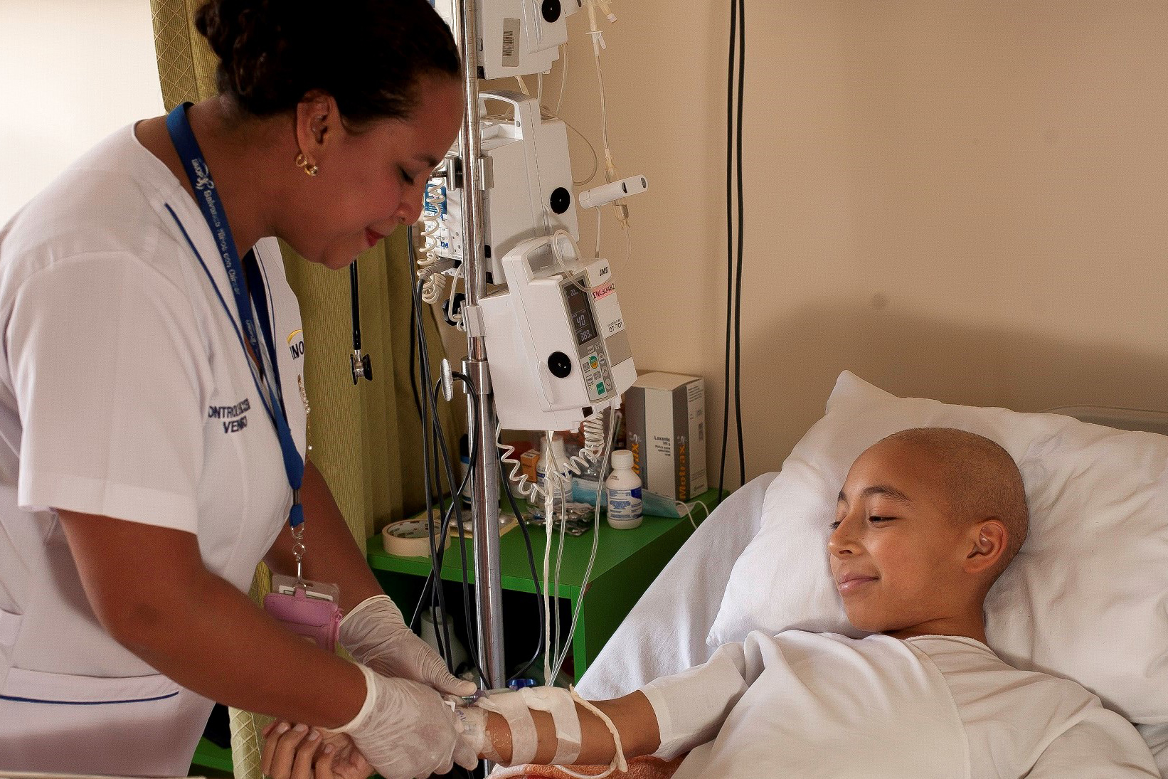 A child with cancer receives treatment from a nurse