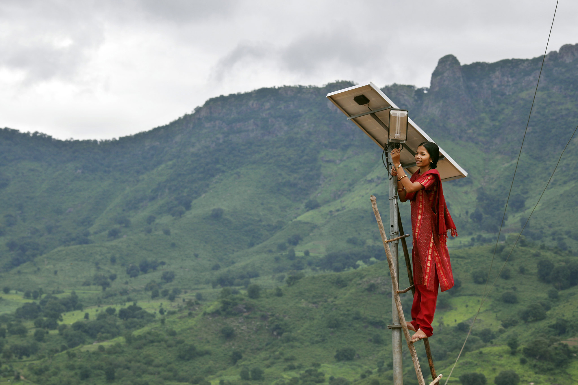 woman engineer on ladder with solar panel