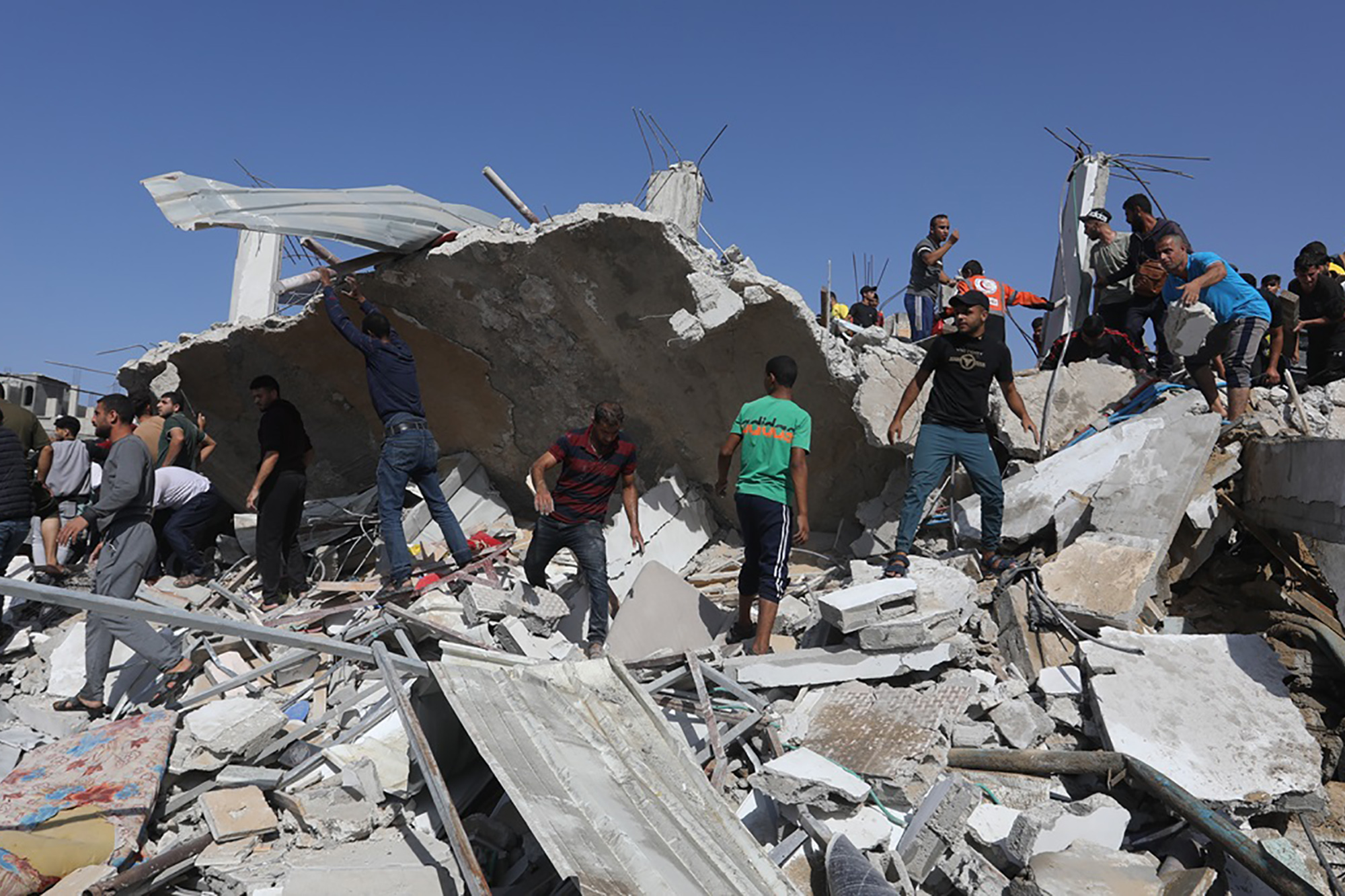 A group of Palestinians inspect a building destroyed by an Israeli air strike on the city of Rafah in the southern Gaza Strip.