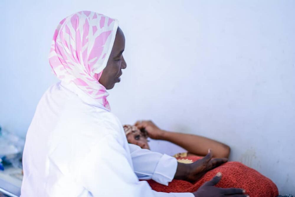 A midwife assessing a pregnant woman in the clinic
