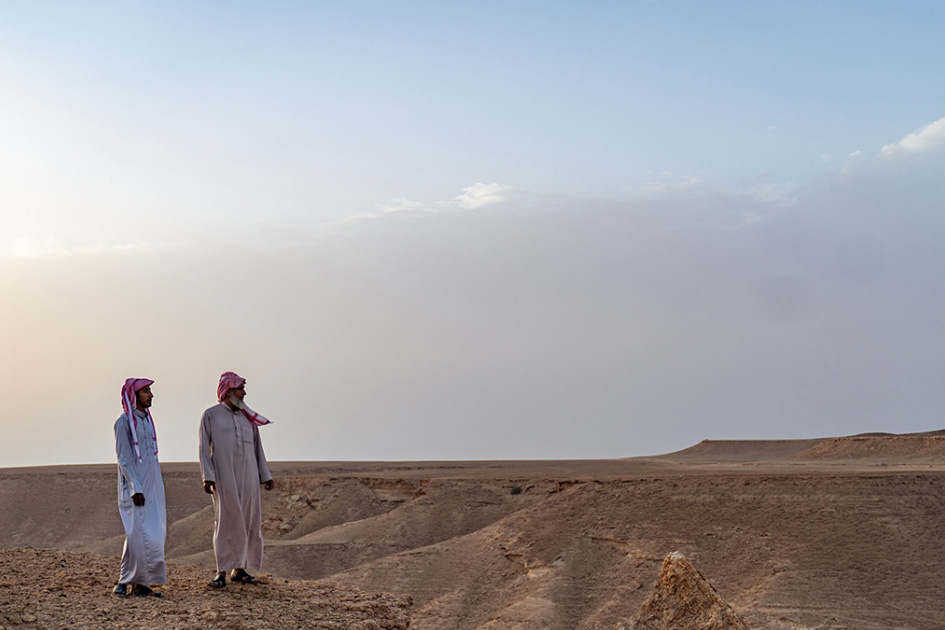 two men standing in the desert