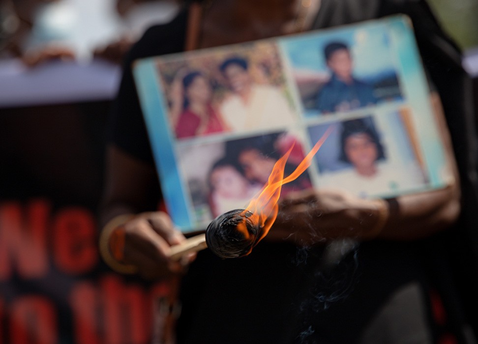 Une flamme devant des photos de membres de familles disparus
