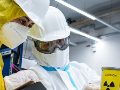 Deux inspecteurs nucléaires examinent un objet portant le symbole de danger radioactif