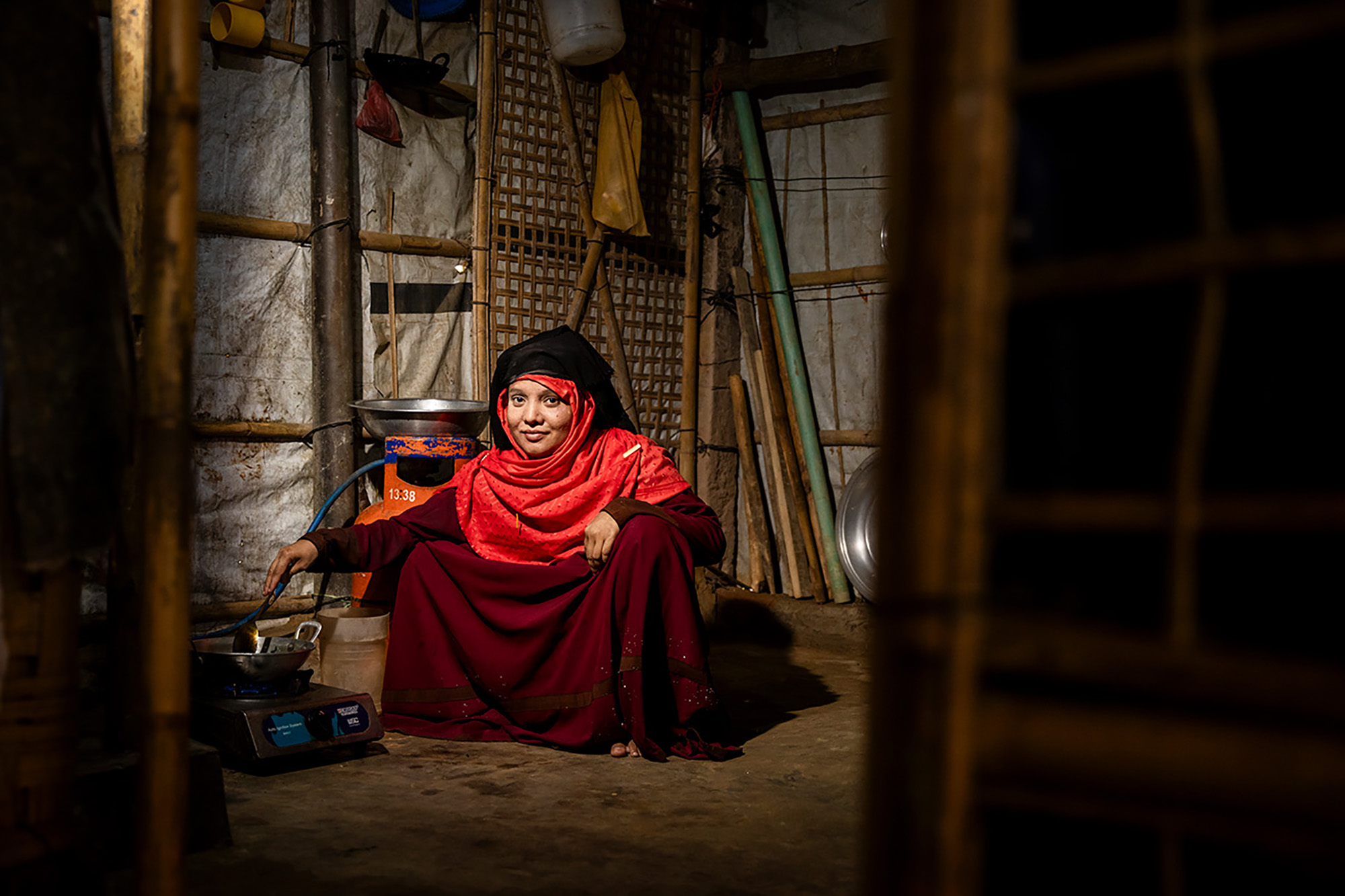 A woman cooking in a humble tent.
