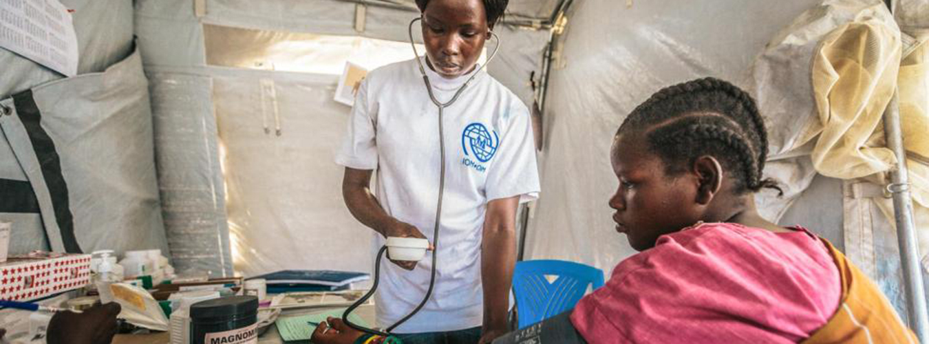 Healthcare worker checks blood pressure of a patient in a temporary clinic