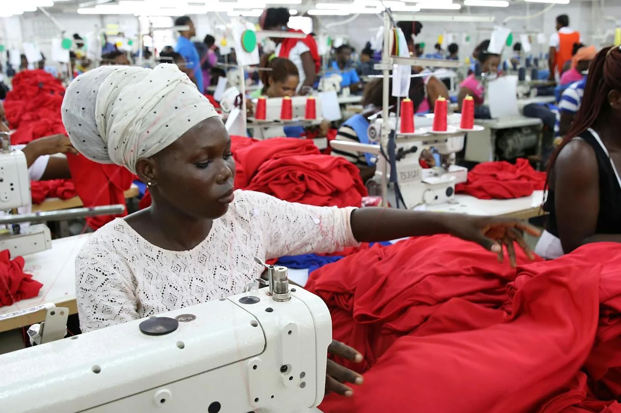 A woman working at a sewing machine in a garment factory.