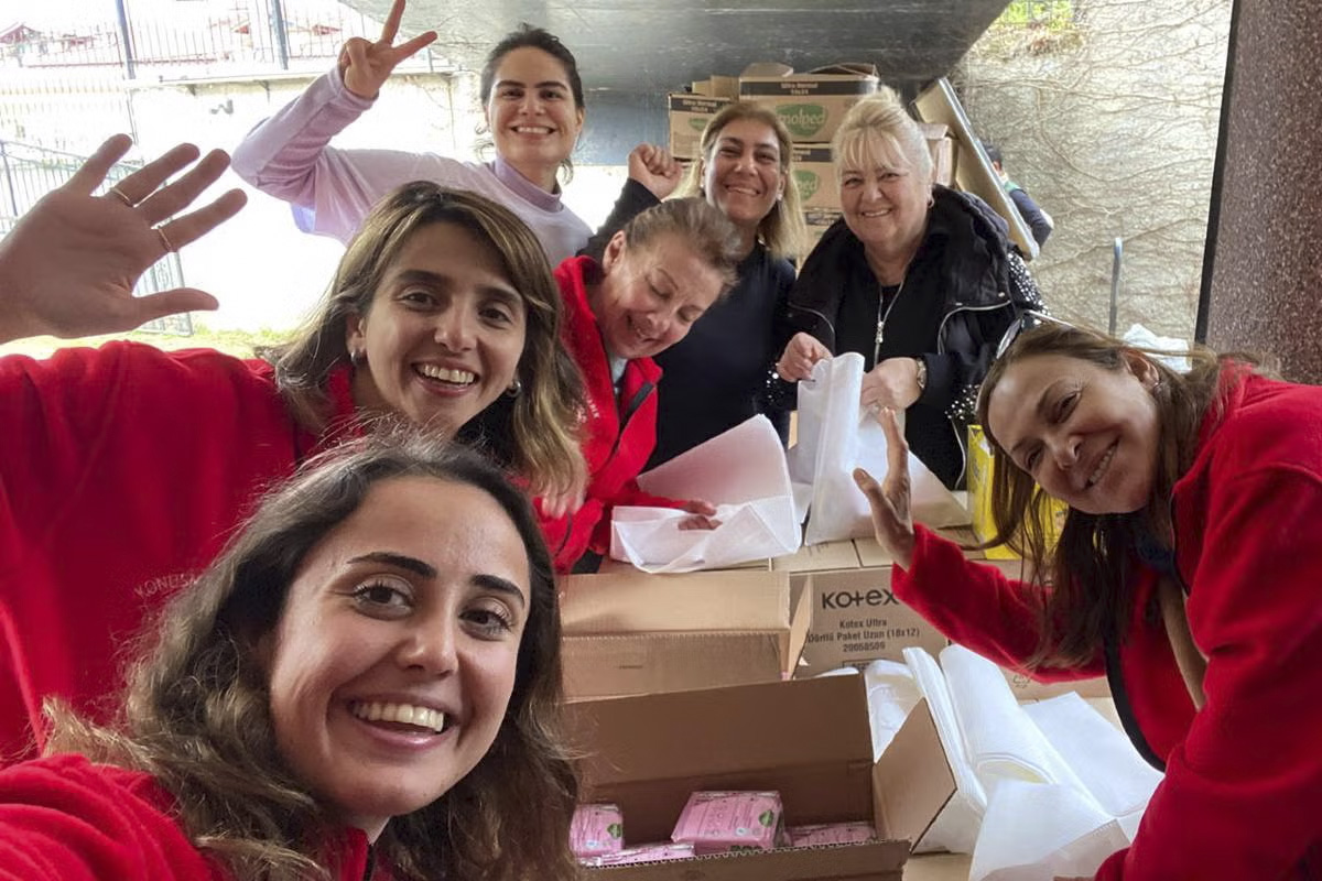 group of women with menstrual supplies smiling