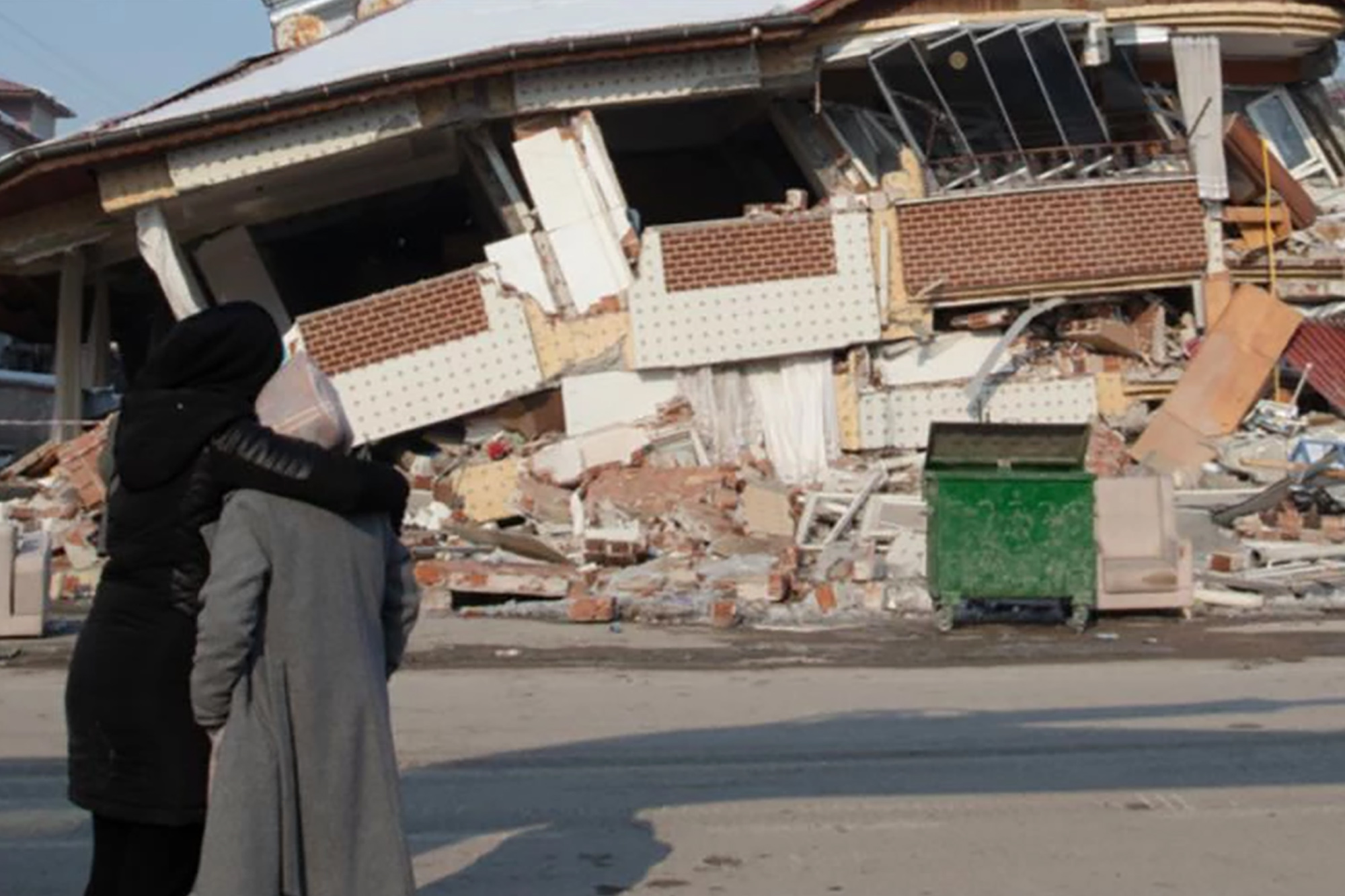 Two women face the ruins of a collapsed building in earthquake-hit Kahramanmaraş, Türkiye