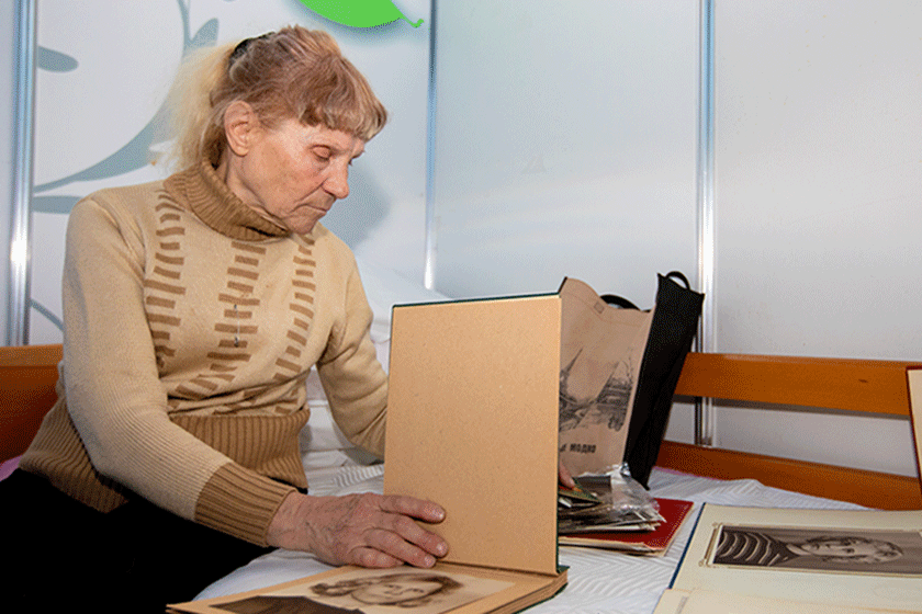 an older woman looks through photo albums