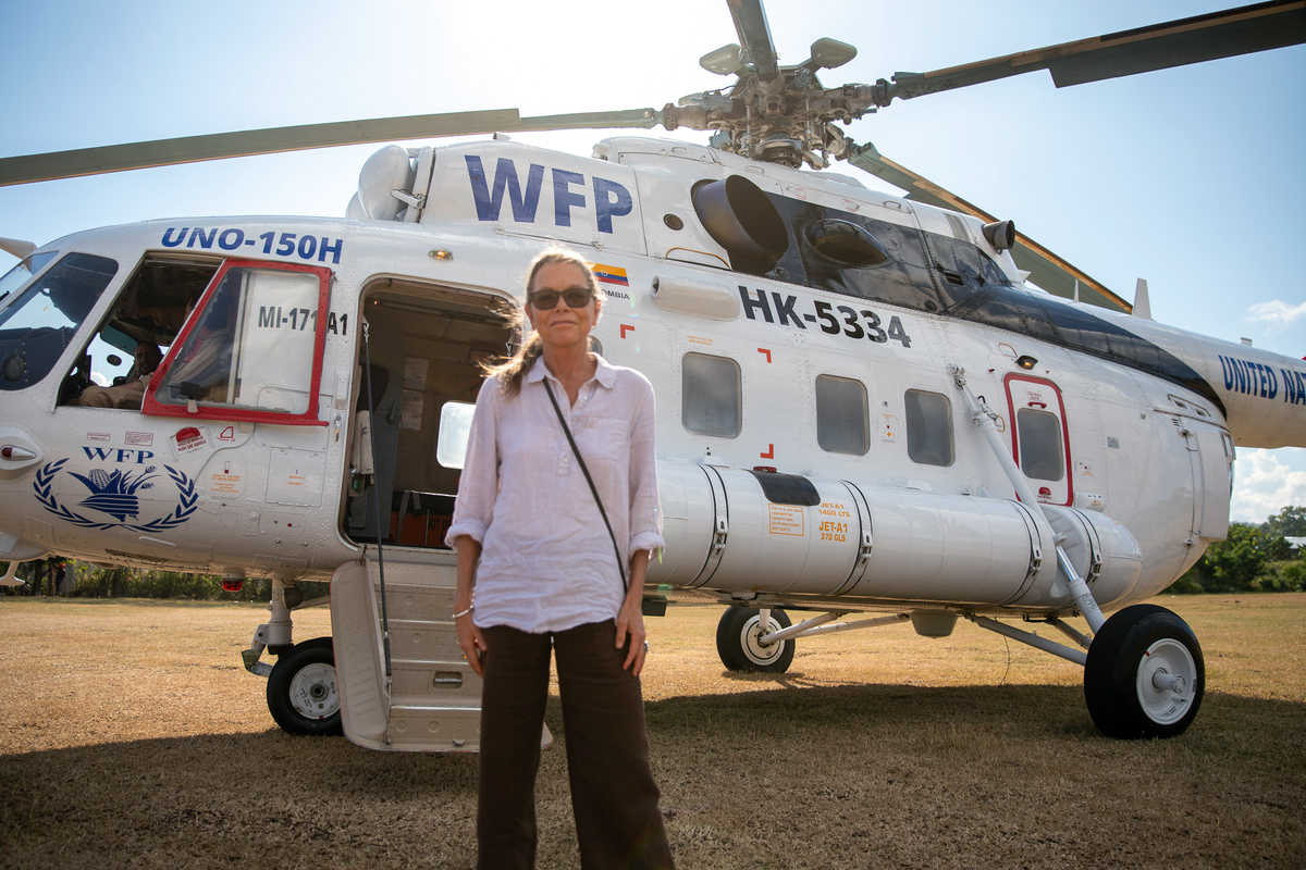 Ulrika Richardson is pictured in front of a WFP helicopter