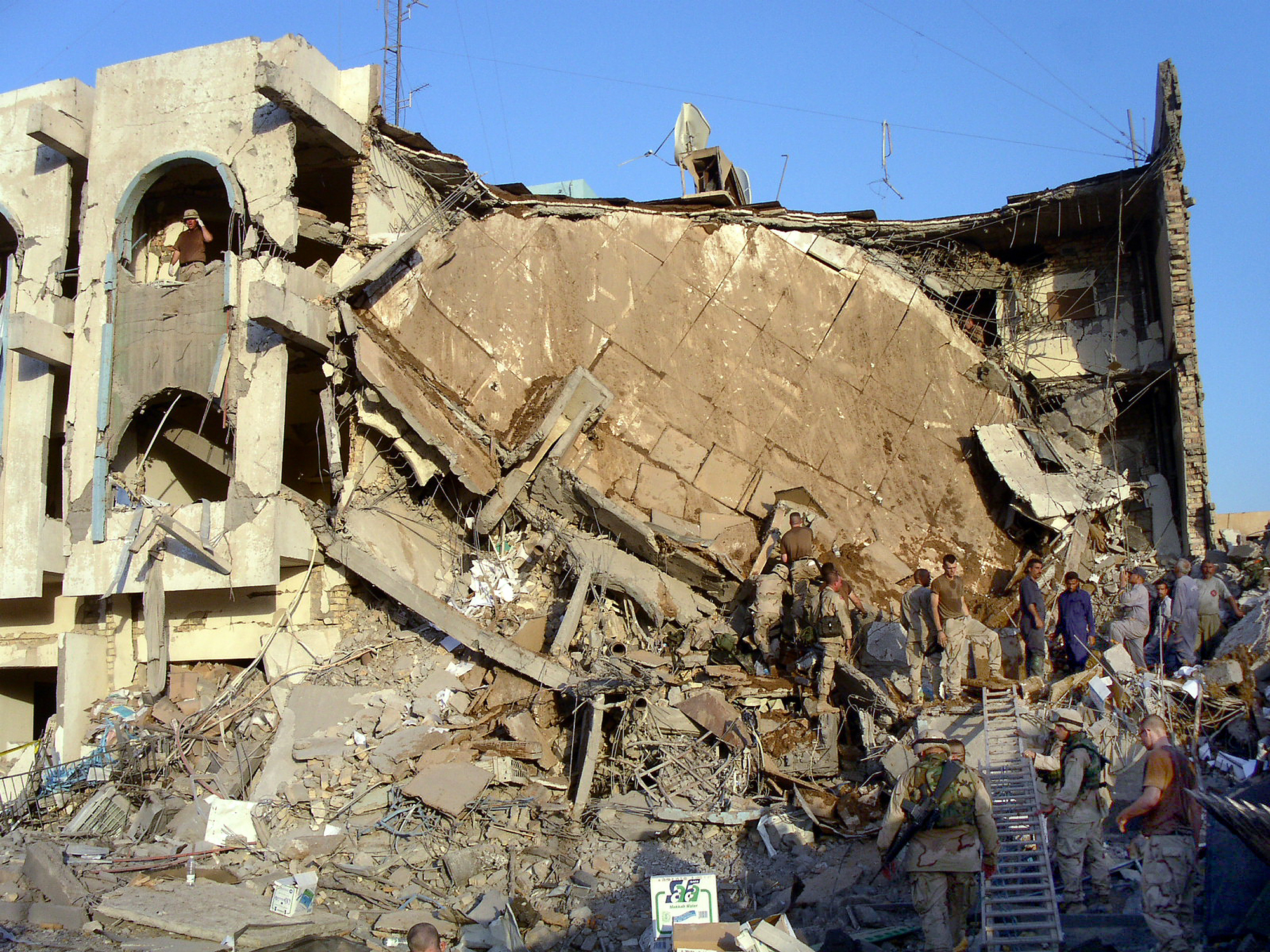Workers and soldiers search through the rubble of United Nations headquarters, Baghdad, after the explosion