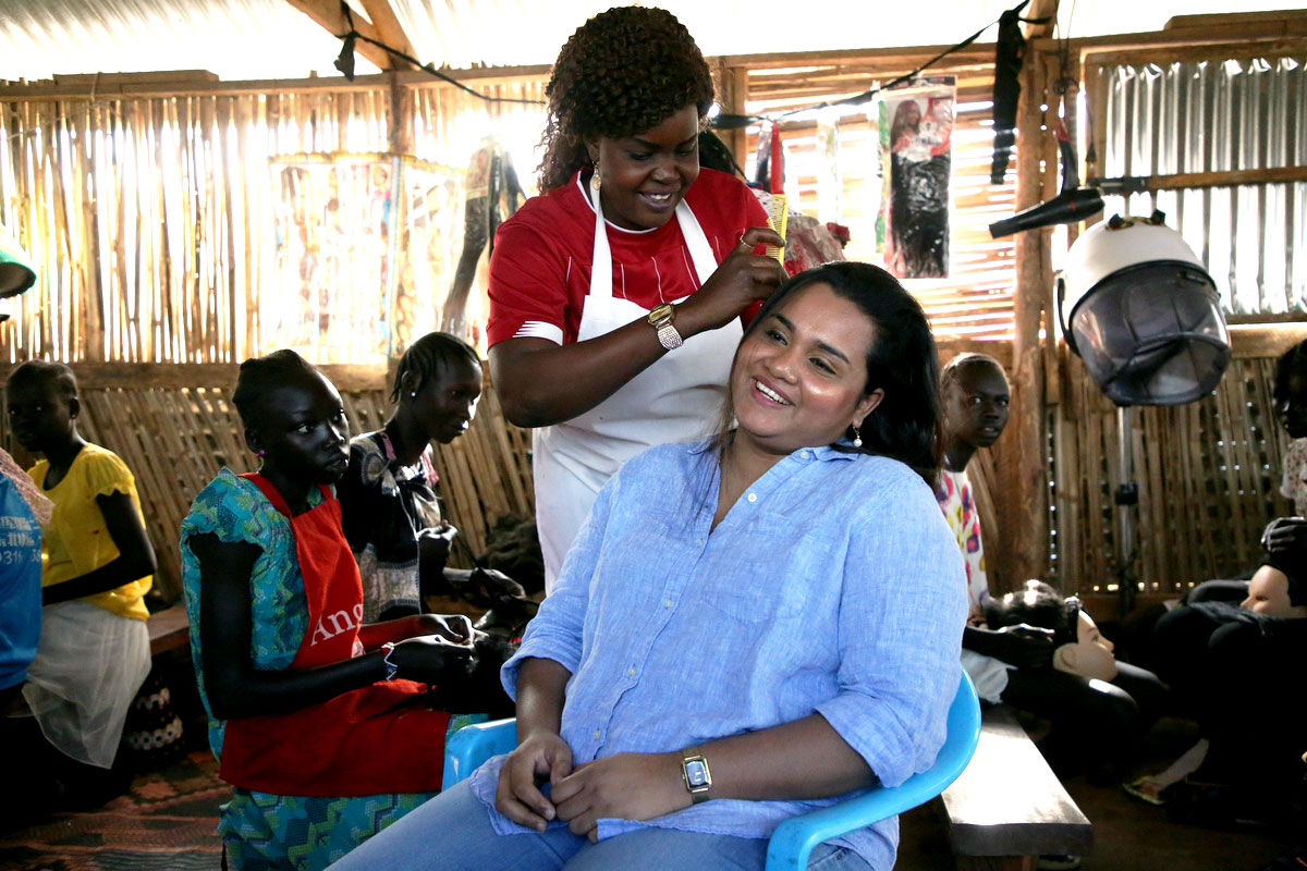 A woman takes care of Jayathma's hair in a training center
