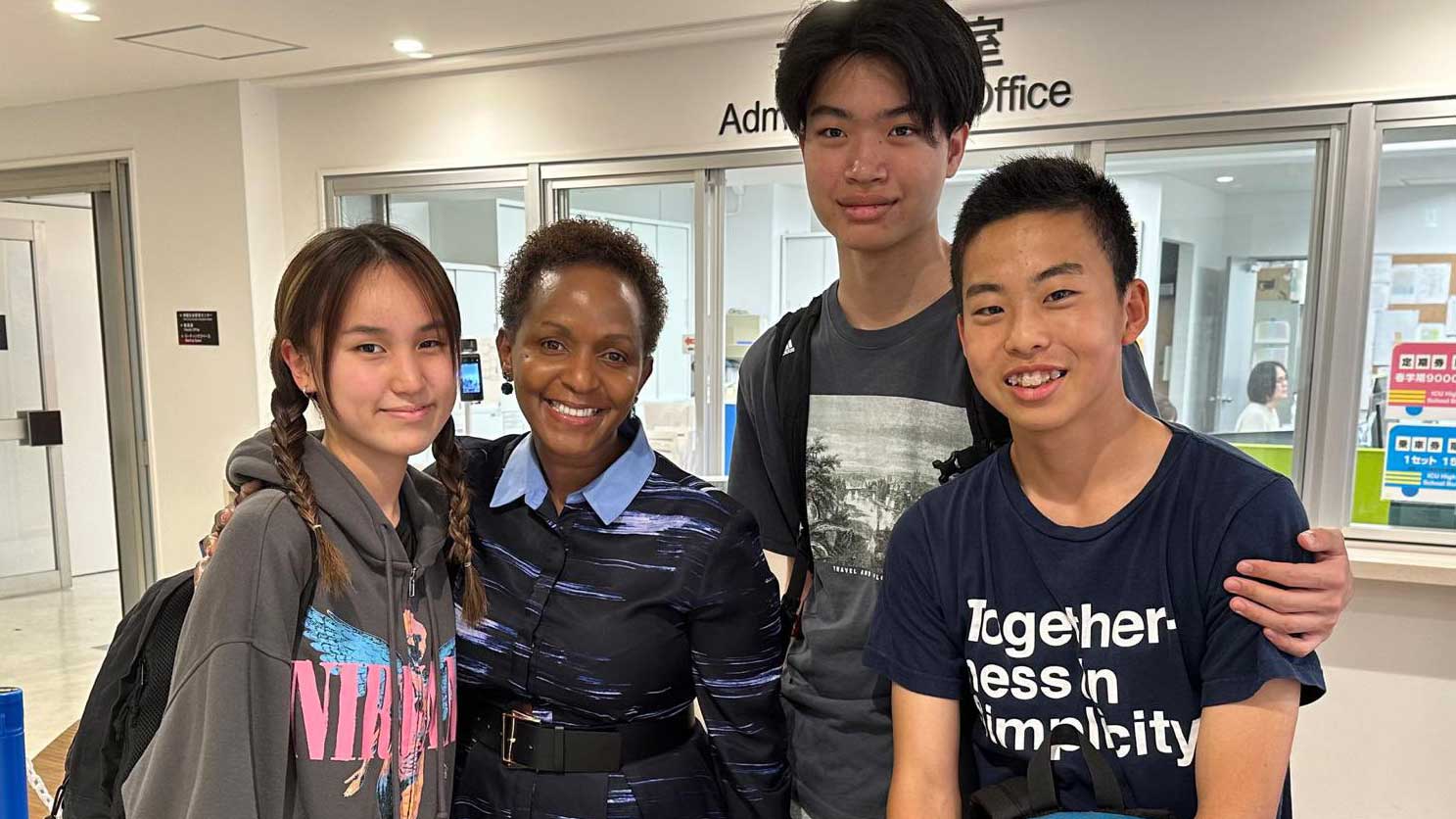 Msuya stands for a photo with young asian students