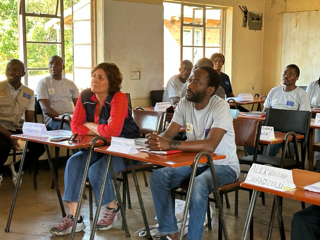 Beth sitting in a rural classroom with other adults